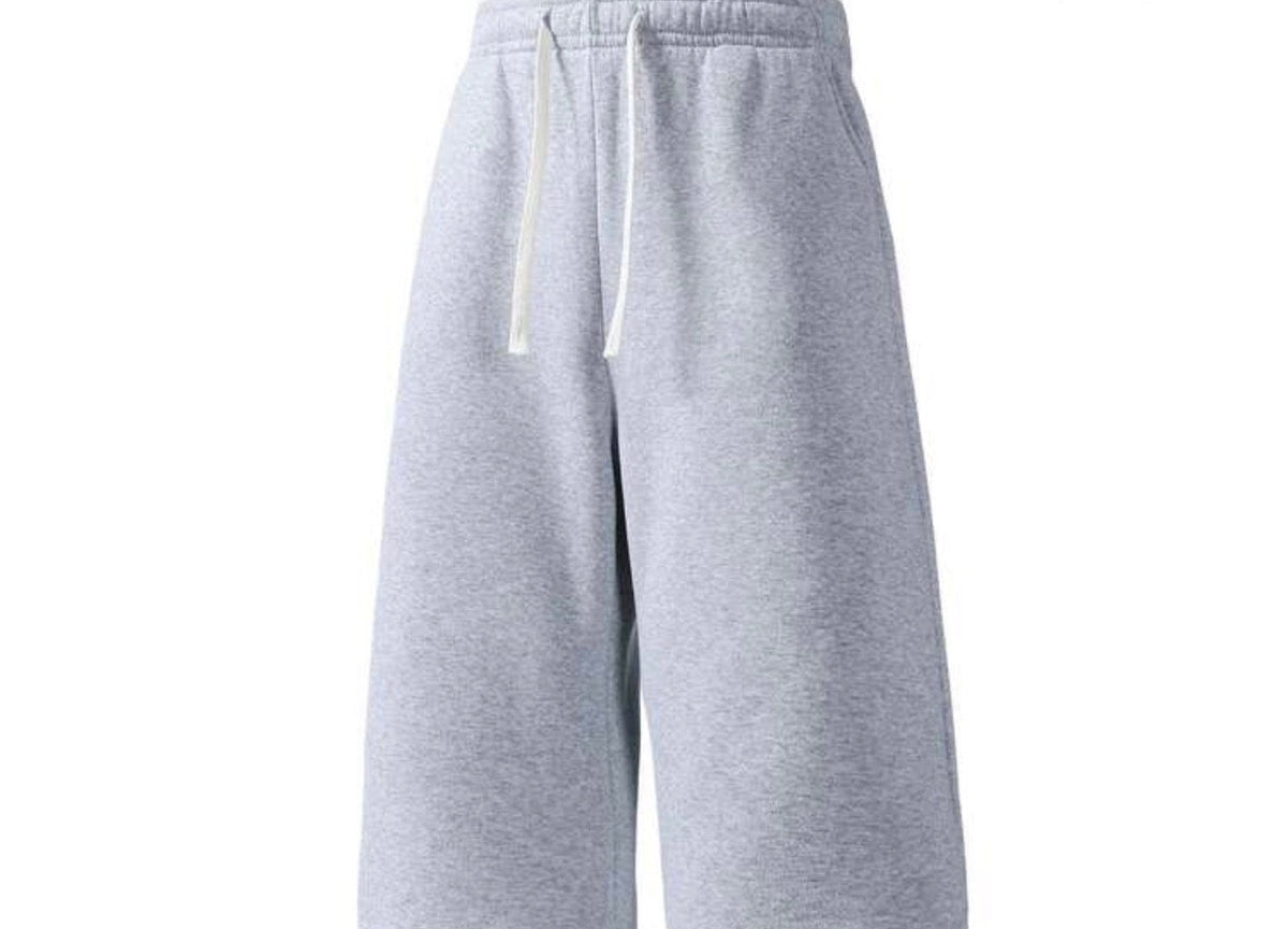 Inflation trending long jogger shorts in black, featuring a relaxed fit with elastic waistband and side pockets.