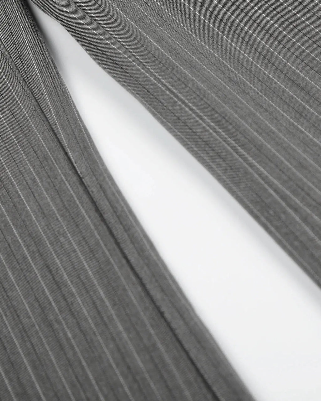 Pinstripe cinch back tailored pants by INFLATION featuring a classic design and sleek fit, shown on a model.