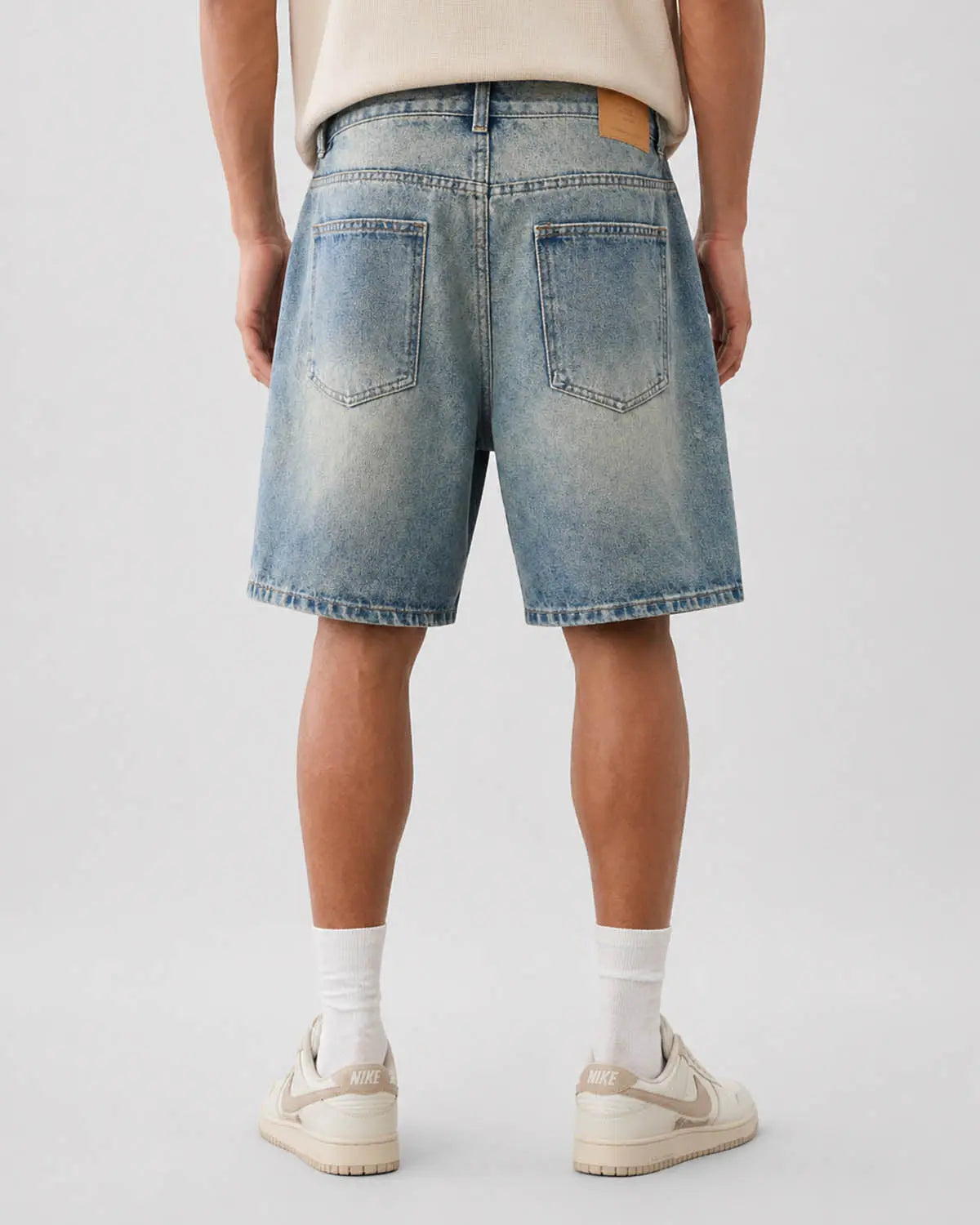 Mid-length washed denim shorts by Inflation Streetwear, showing casual style with distressed details and a relaxed fit.