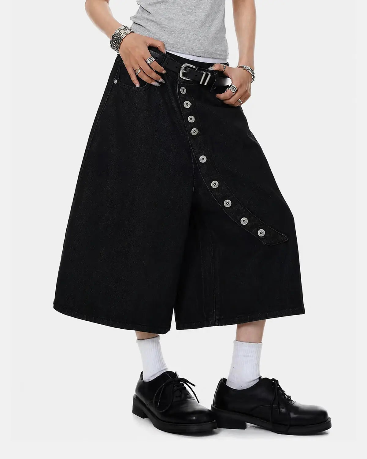 Asymmetric button raw denim jorts by INFLATION featuring distressed raw denim and unique asymmetric button closure for streetwear style.