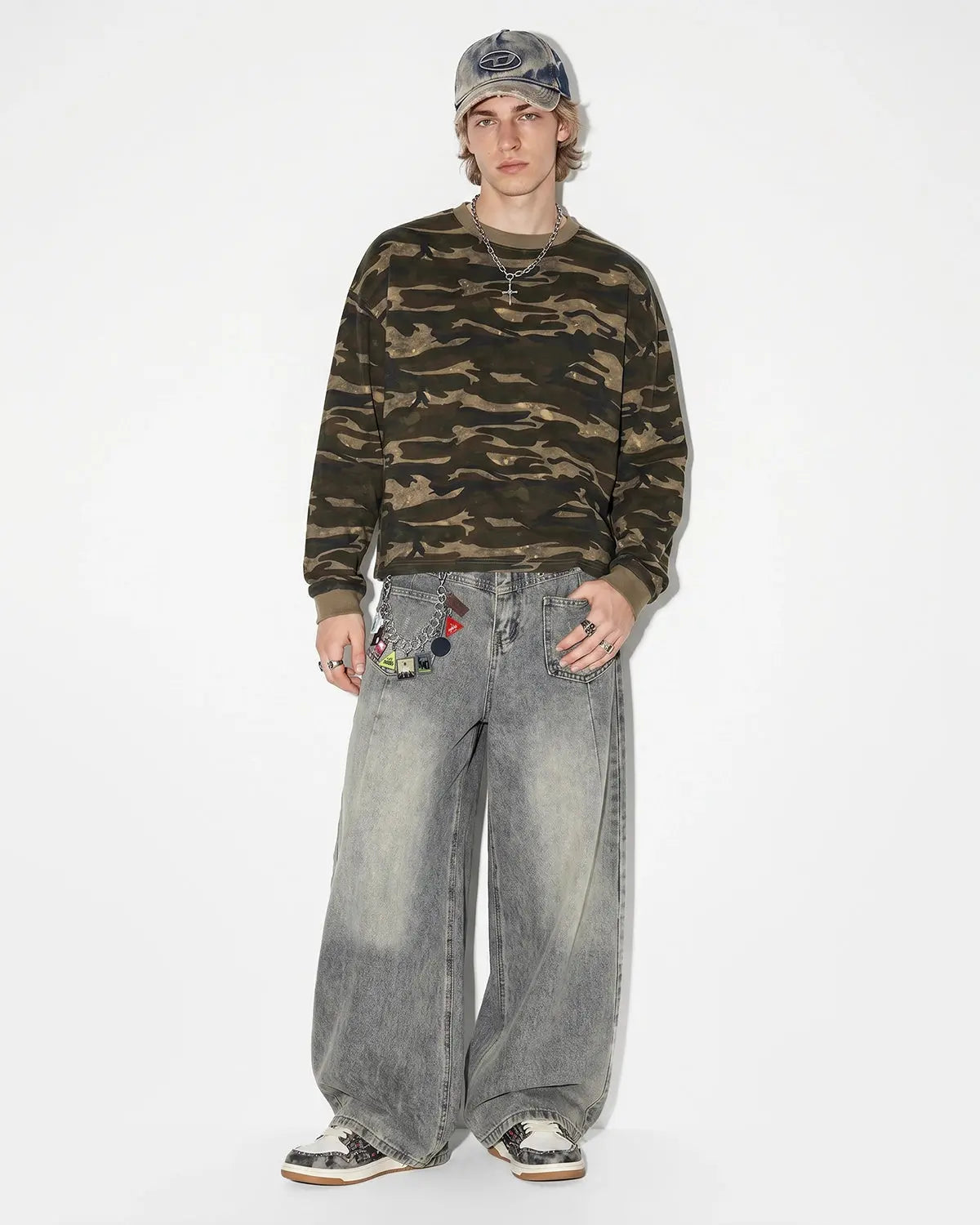 Distressed eyelet barrel jeans by INFLATION featuring ripped details, eyelet accents, and a relaxed fit on model.