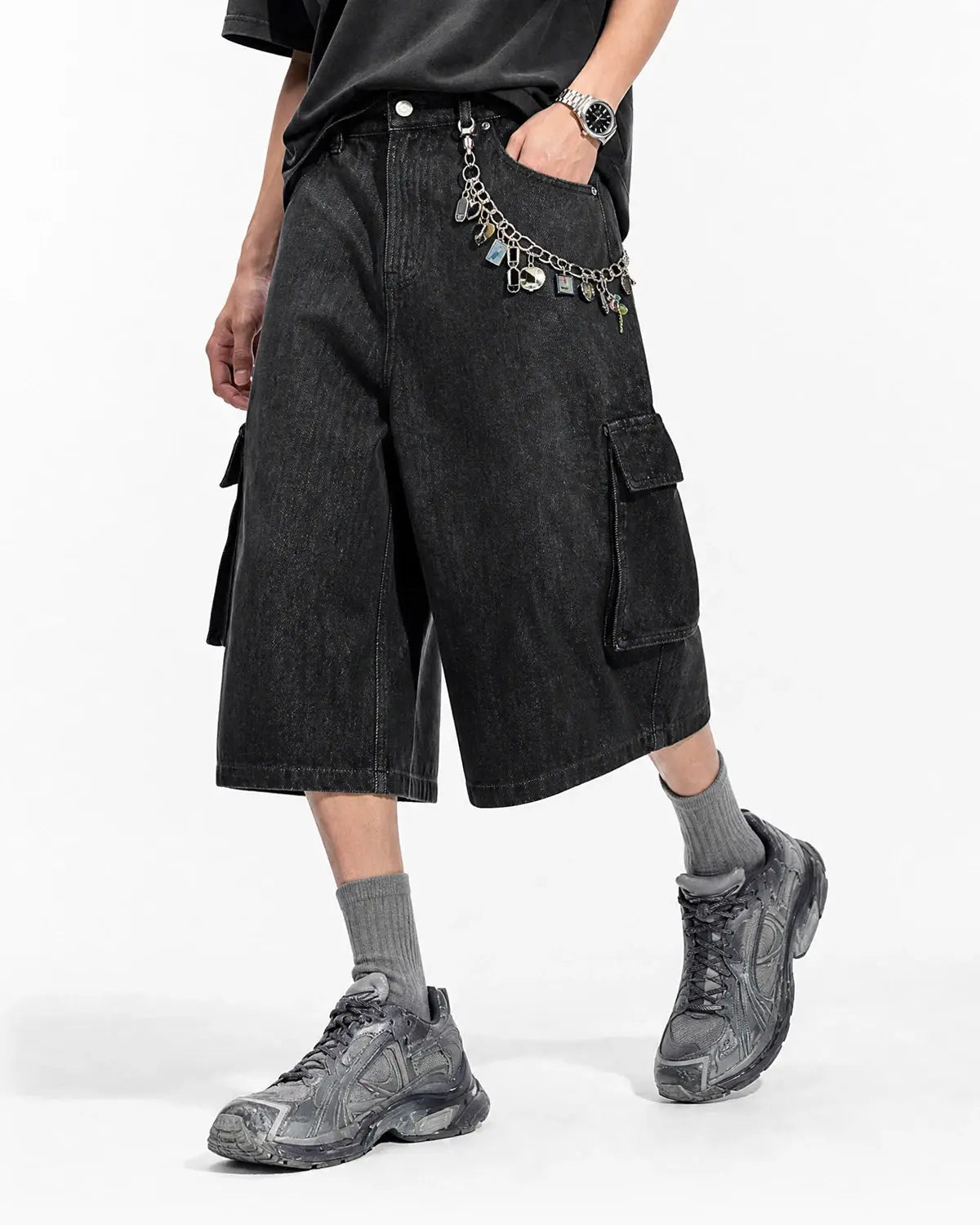 Black cargo longline jorts by INFLATION, featuring a relaxed fit, multiple cargo pockets, and distressed denim details.