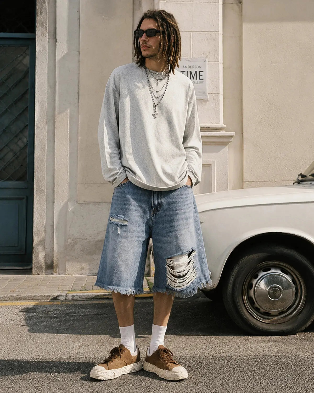 Distressed baggy jorts with adjustable waist tabs, casual streetwear pants by INFLATION, featuring a relaxed fit and rugged denim look.