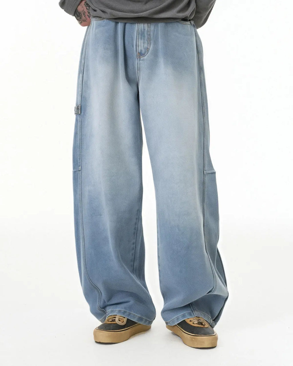 Distressed baggy cargo jeans by INFLATION featuring a relaxed fit, multiple pockets, and a worn, vintage style.