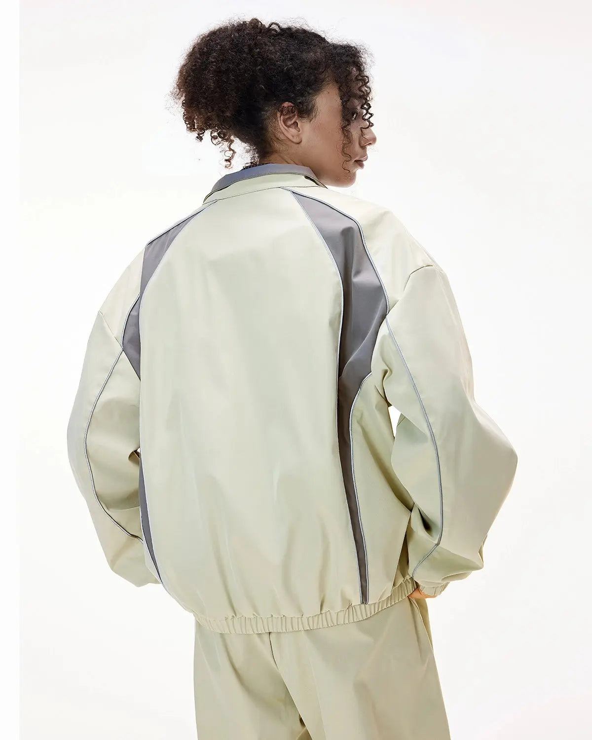 Reflective windbreaker track jacket by INFLATION with neon accents, lightweight fabric, and reflective details for visibility.