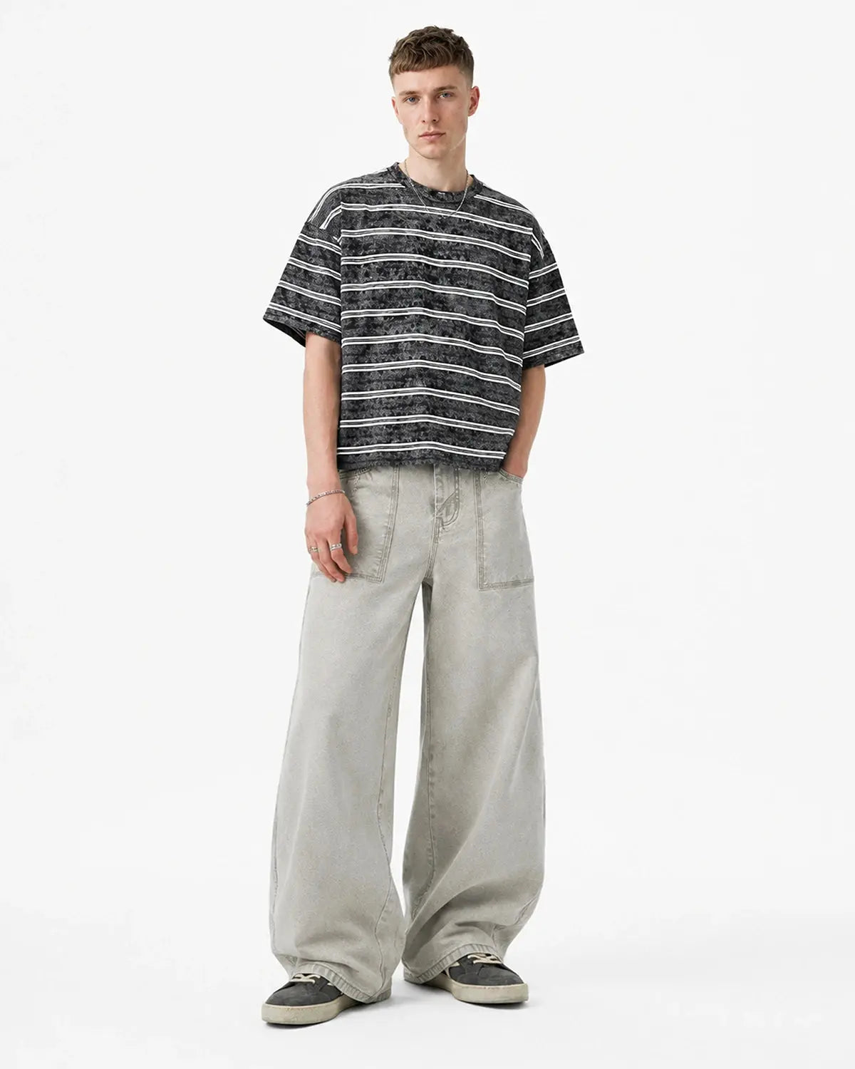Deconstructed distressed barrel jeans by INFLATION featuring ripped details and a relaxed streetwear style.
