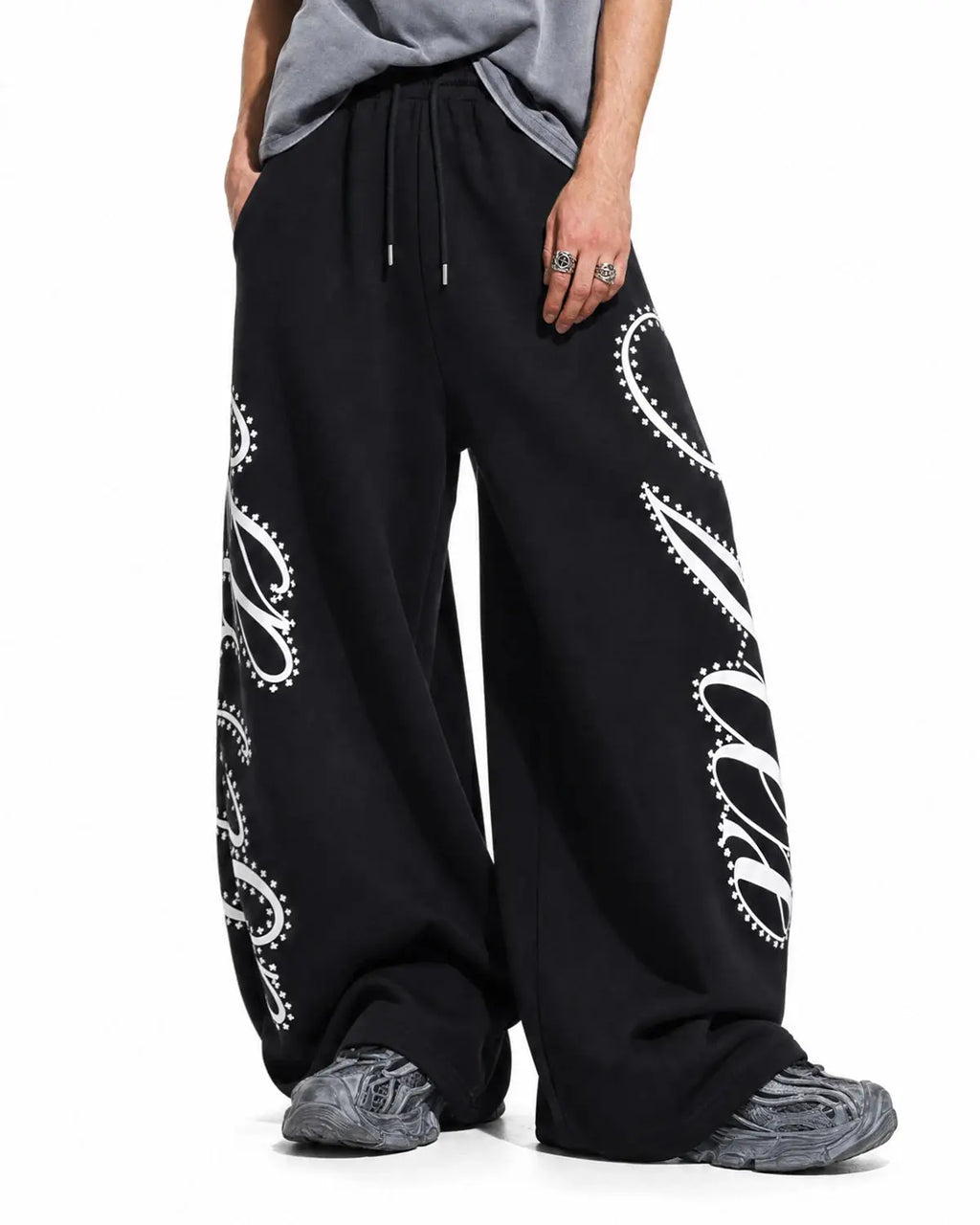 Inflation Streetwear rhinestone script baggy sweatpants with embellished logo and relaxed fit, shown in a stylish streetwear setting.