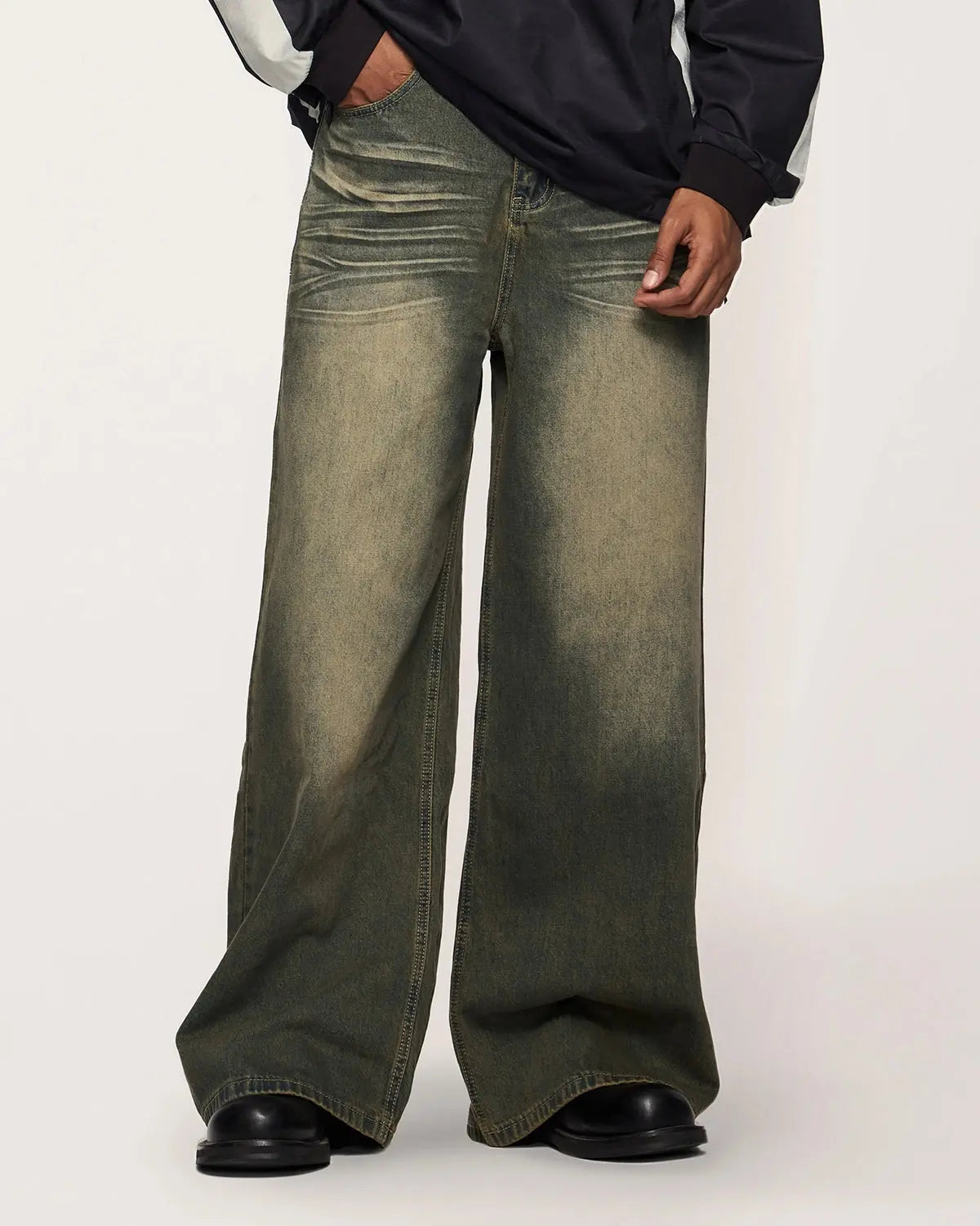 Inflation washed loose-fit denim pants featuring distressed details and casual streetwear style, displayed on a model.