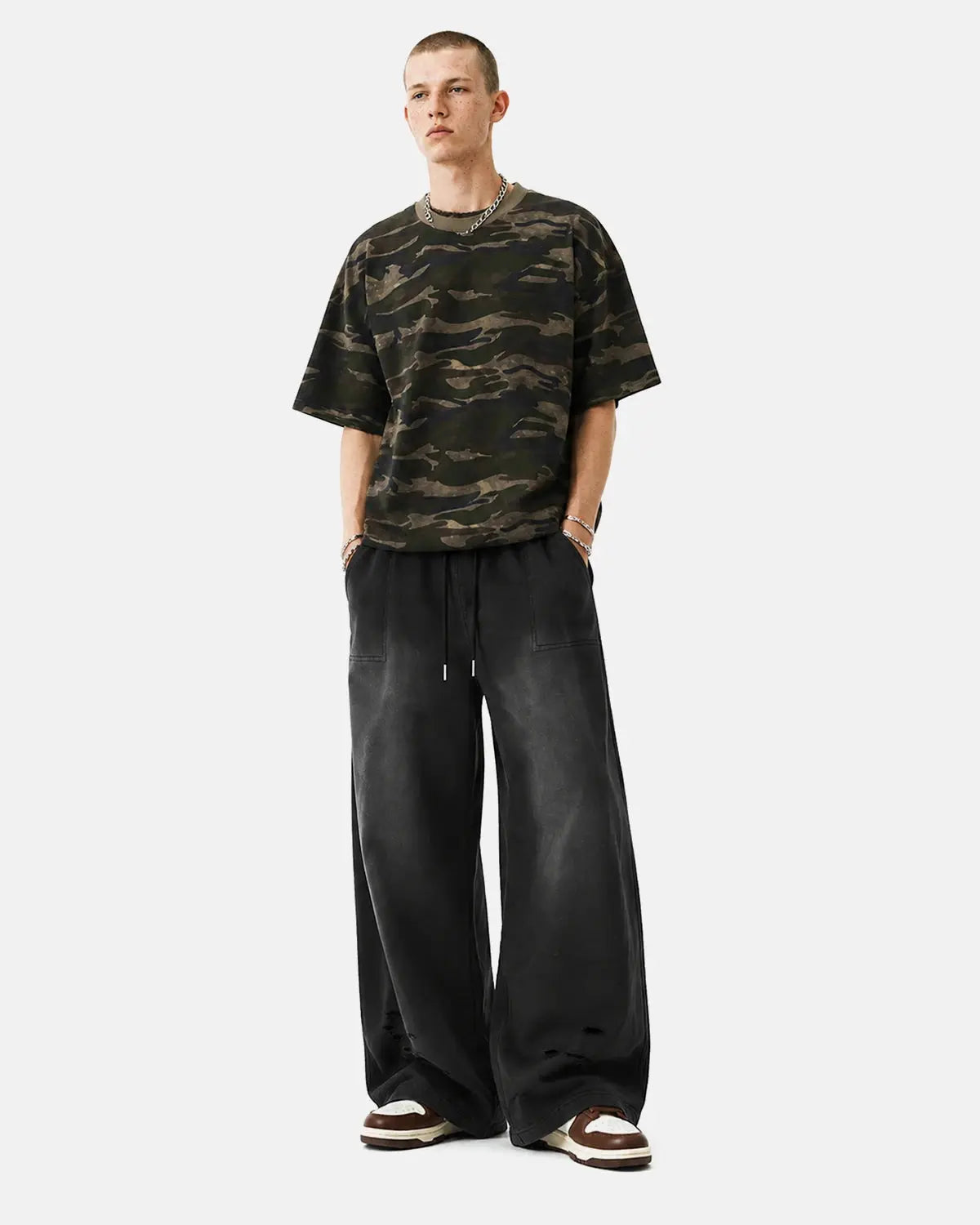 Distressed washed baggy sweatpants by INFLATION, featuring a relaxed fit and faded denim style with ripped details.