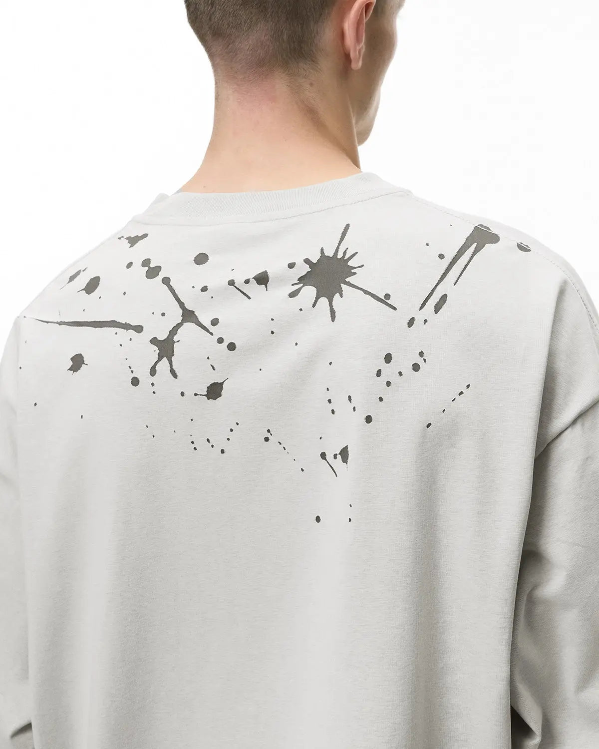 Laser burning streetwear tee by INFLATION featuring a bold, graphic design on black fabric for urban style.