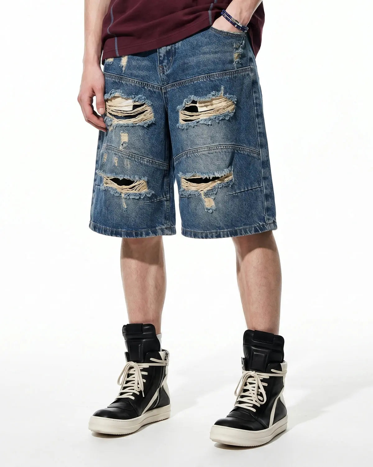Inflation brand heavy washed distressed baggy jorts, denim pants with a relaxed fit and frayed edges, casual streetwear style.