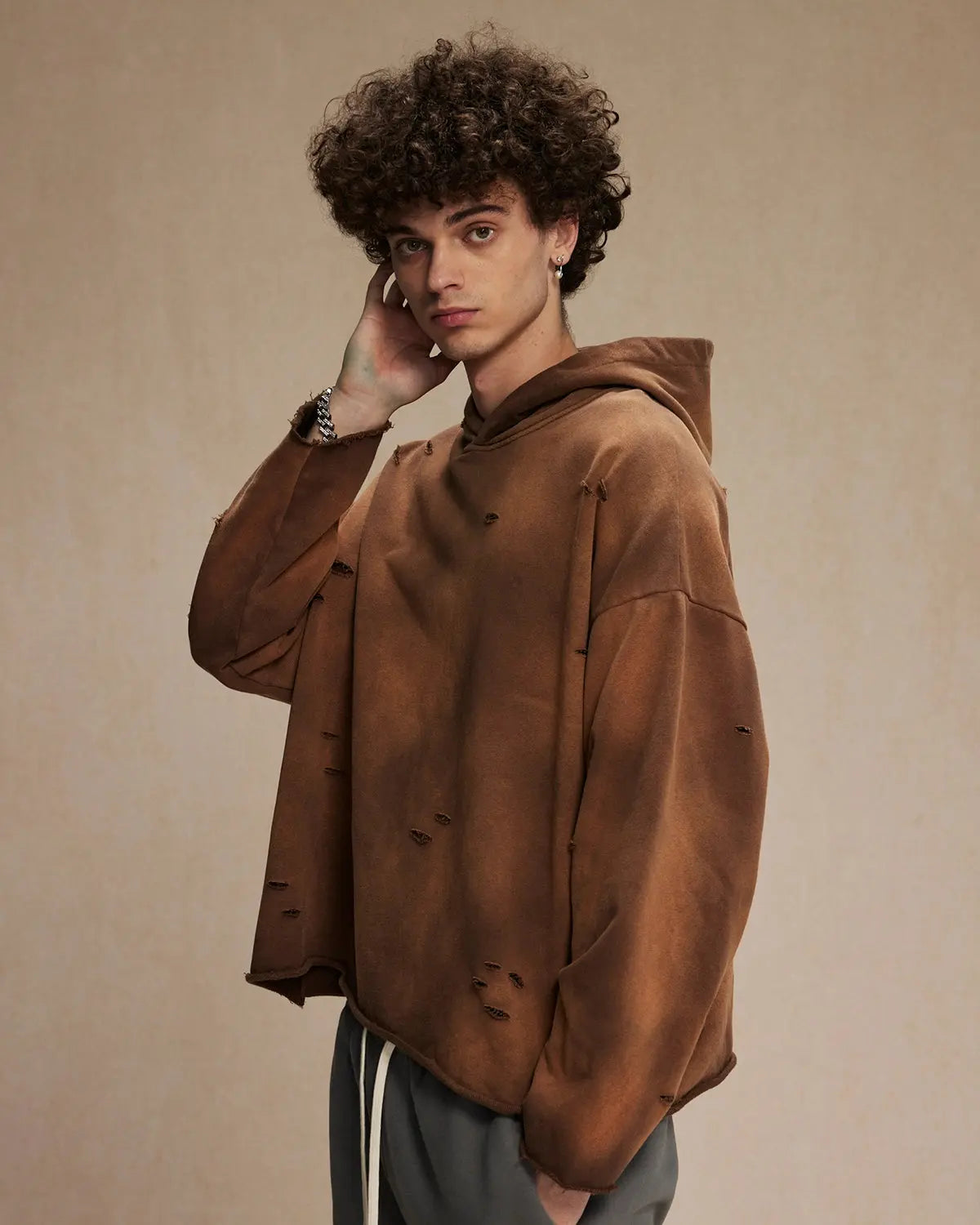 Acid wash ripped boxy hoodie by INFLATION featuring distressed details and a relaxed fit, styled with casual streetwear vibe.