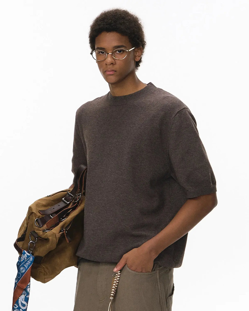 Short-sleeved crewneck sweater by INFLATION, featuring knitwear design, shown in a close-up of the beige color and textured fabric.