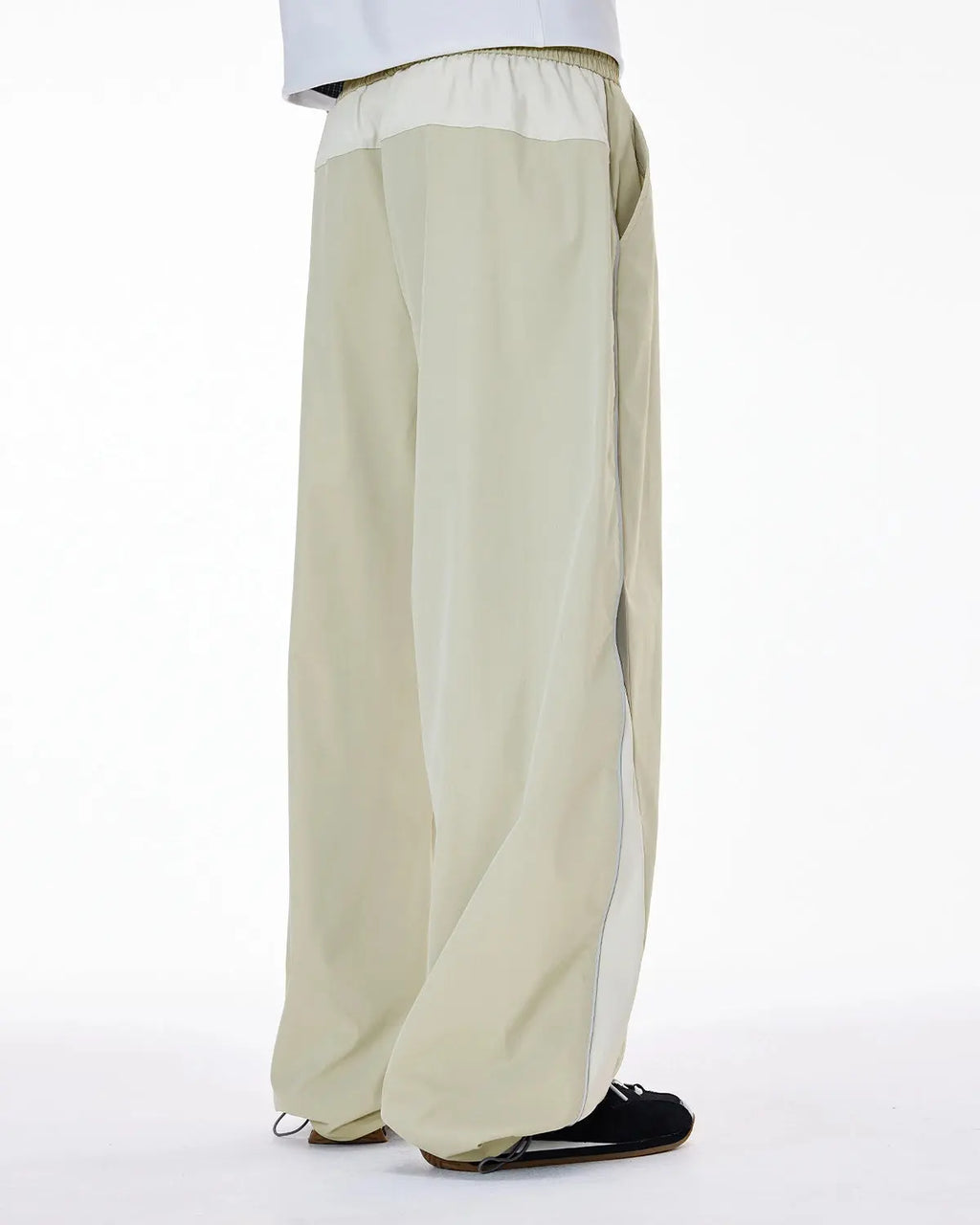 Reflective windbreaker track pants by INFLATION featuring a sleek, sporty design with reflective accents for active streetwear.