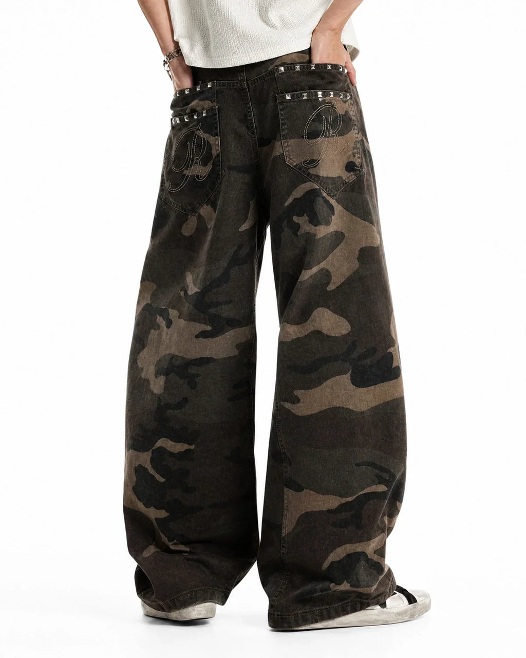 Inflation Streetwear studded camo barrel jeans, men's casual pants with metal stud accents in green and brown camouflage print.