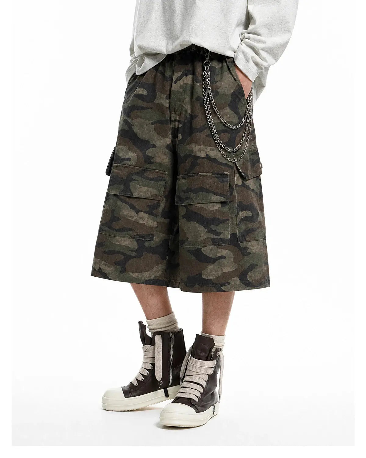 Grey camo utility longline shorts by INFLATION, featuring multiple pockets and a relaxed fit on a neutral background.