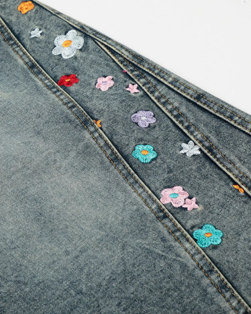 Floral embroidered long baggy jorts by INFLATION, stylish streetwear pants with colorful floral embroidery and relaxed fit.