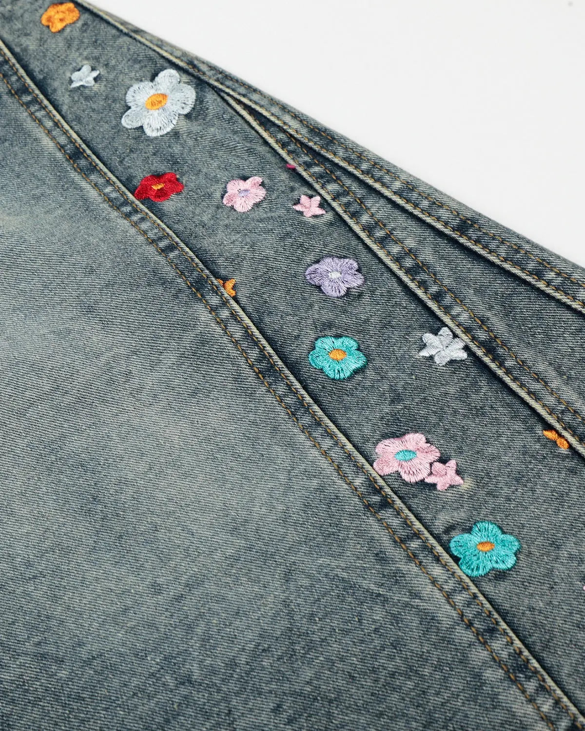 Floral embroidered long baggy jorts by INFLATION, stylish streetwear pants with colorful floral embroidery and relaxed fit.