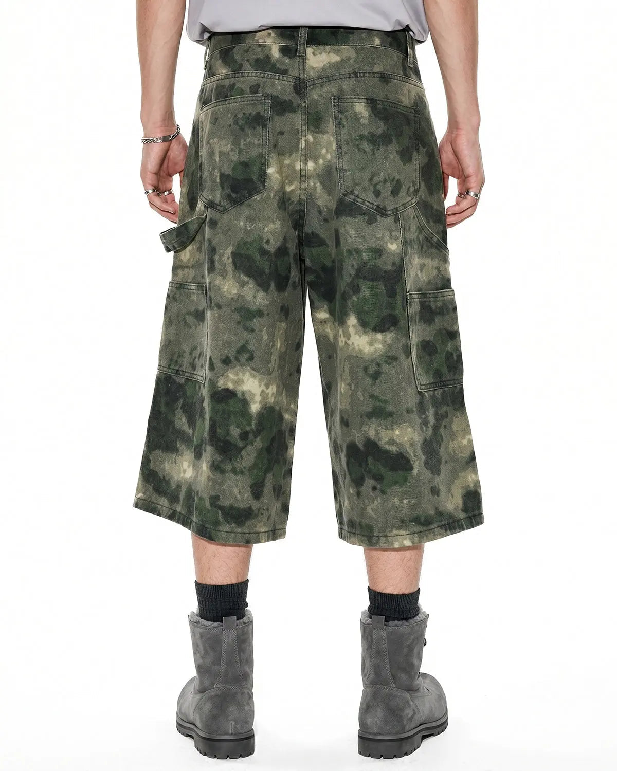 Washed camo cargo longline shorts by INFLATION, featuring multiple pockets and a relaxed fit, styled with a streetwear look.