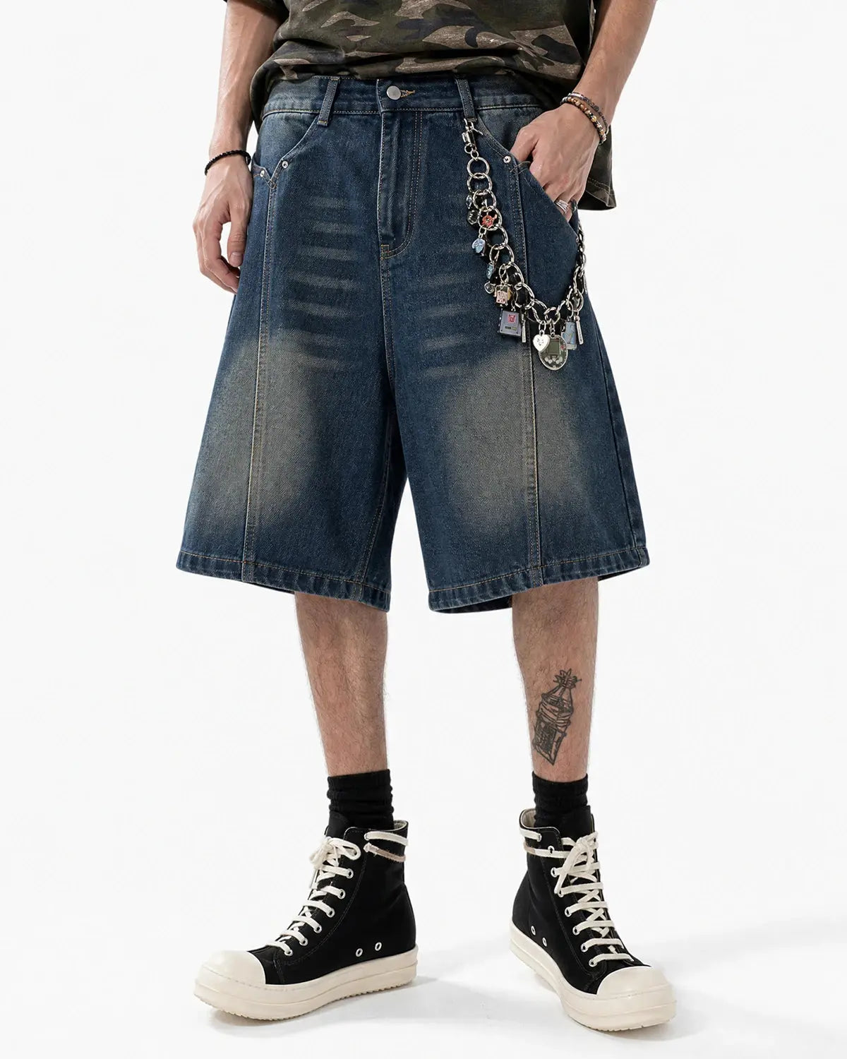 Deconstructed washed denim Jorts by INFLATION, casual streetwear pants with ripped and frayed details, laid flat on a white background.
