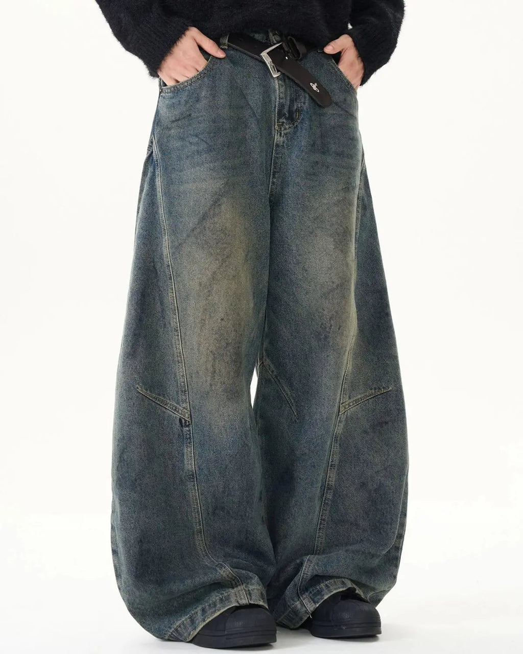 Washed deconstructed barrel jeans by INFLATION featuring distressed details, relaxed fit, and unique raw hem for streetwear style.