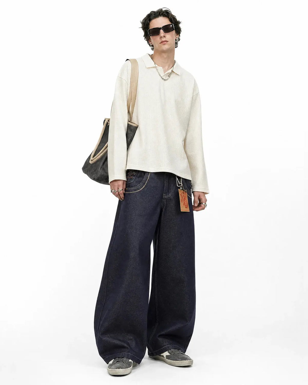 Side lace-up raw baggy jeans by INFLATION featuring a loose fit and distressed denim style, shown on a model.