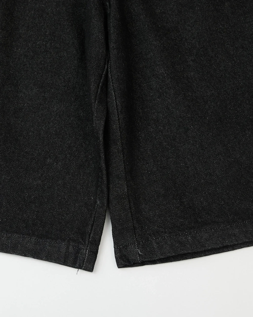 Black baggy long jorts from INFLATION streetwear, featuring oversized denim shorts with a relaxed fit and cuffed hems.