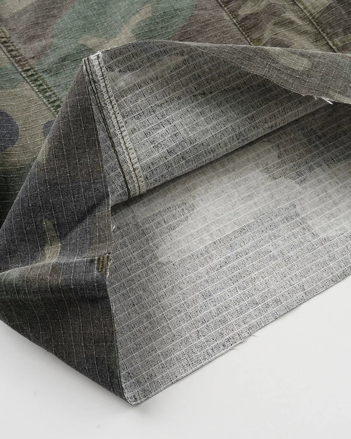Camo utility longline shorts by INFLATION featuring a military-style camouflage pattern and multiple utility pockets.