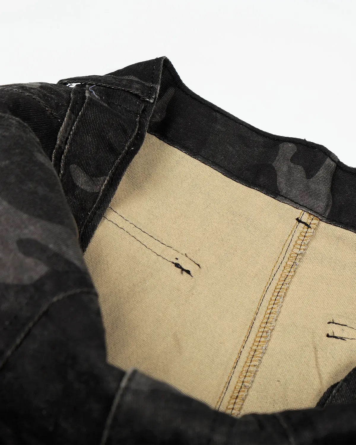 Dark camouflage cargo shorts by INFLATION, showing multiple pockets, relaxed fit, and streetwear style on a neutral background.