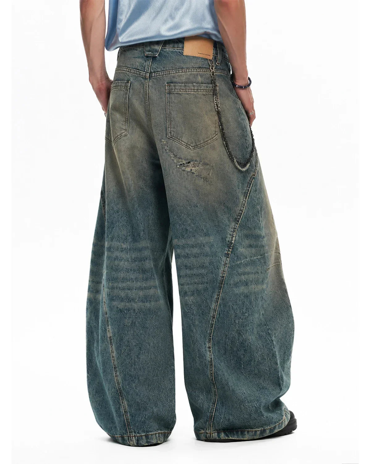 Distressed blue barrel jeans by INFLATION featuring a dirty wash look and vintage-style distressing, casual streetwear denim.
