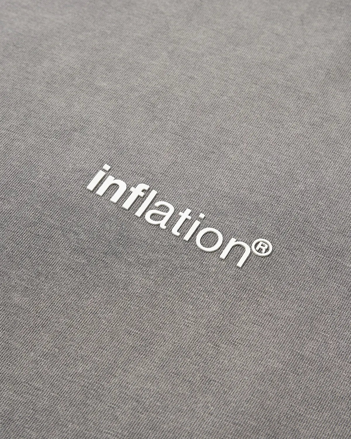 Inflation Brand Washed Long Sleeve T-shirt in neutral color, relaxed fit, casual streetwear style with printed logo on front.
