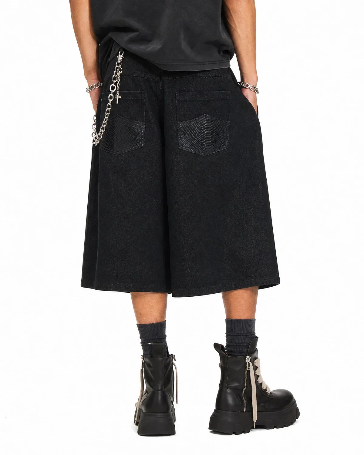 Black baggy long jorts by Inflation Streetwear, featuring loose fit denim style with distressed details and wide leg design.