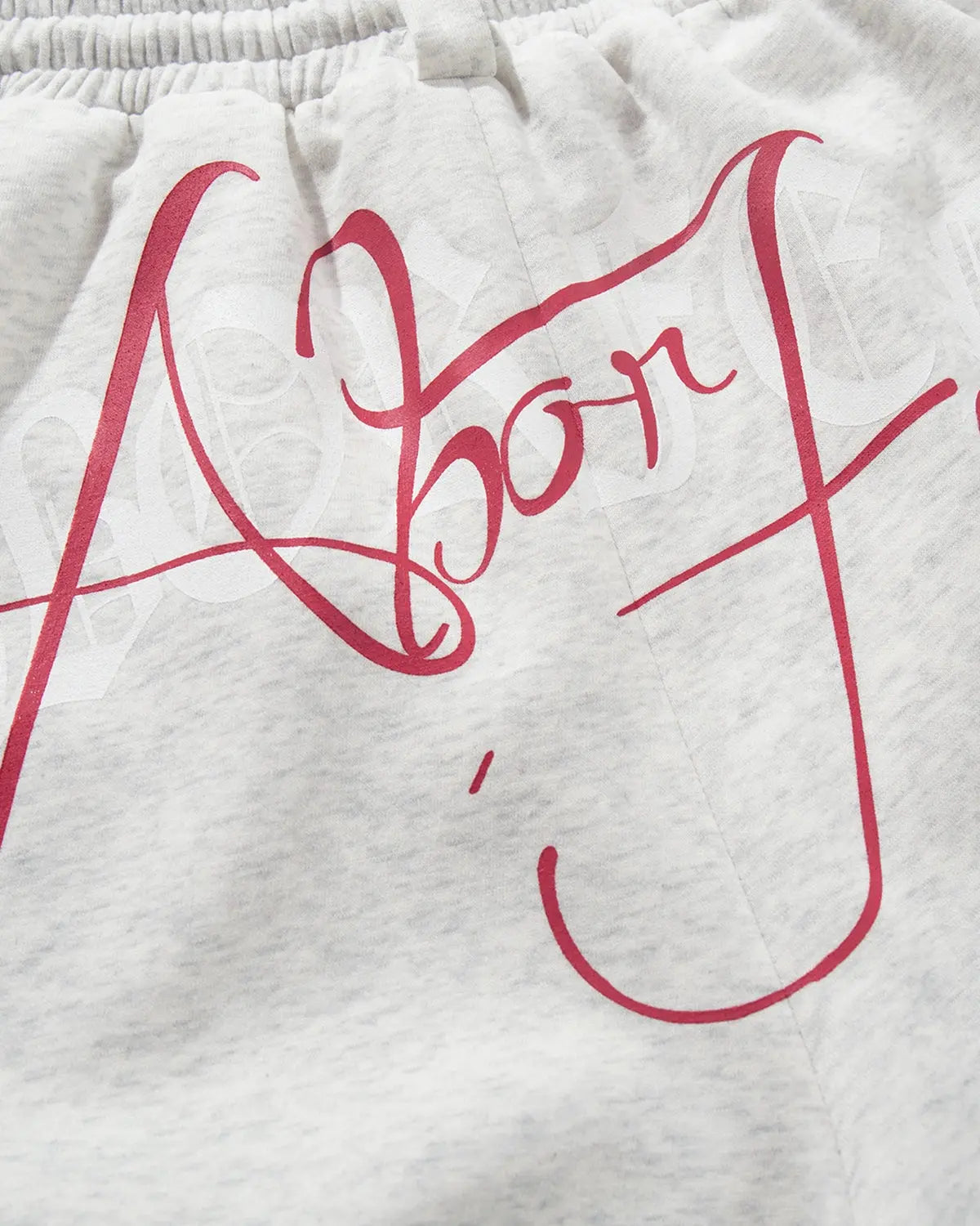 Inflation Gothic Script Baggy Sweatpants with bold black Gothic lettering, relaxed fit, and streetwear style, shown on model.