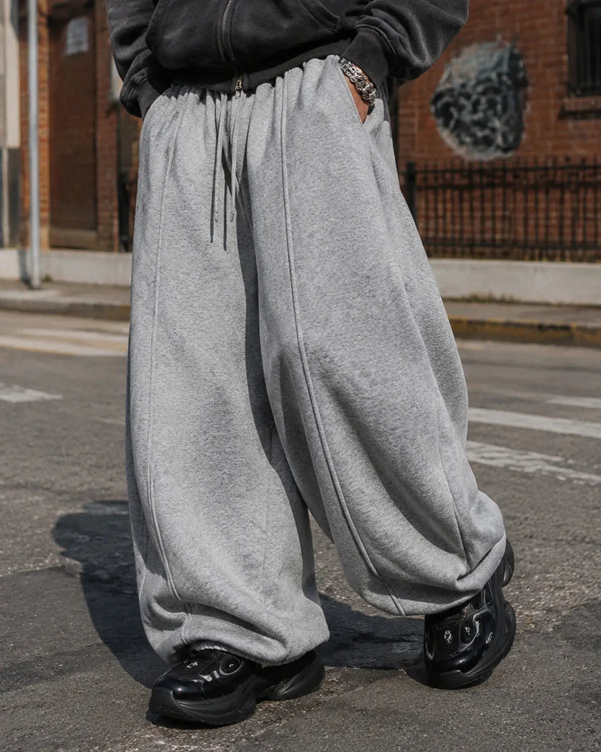 Grey baggy jogger sweatpants by INFLATION with relaxed fit and elastic waistband, shown on a hanger.