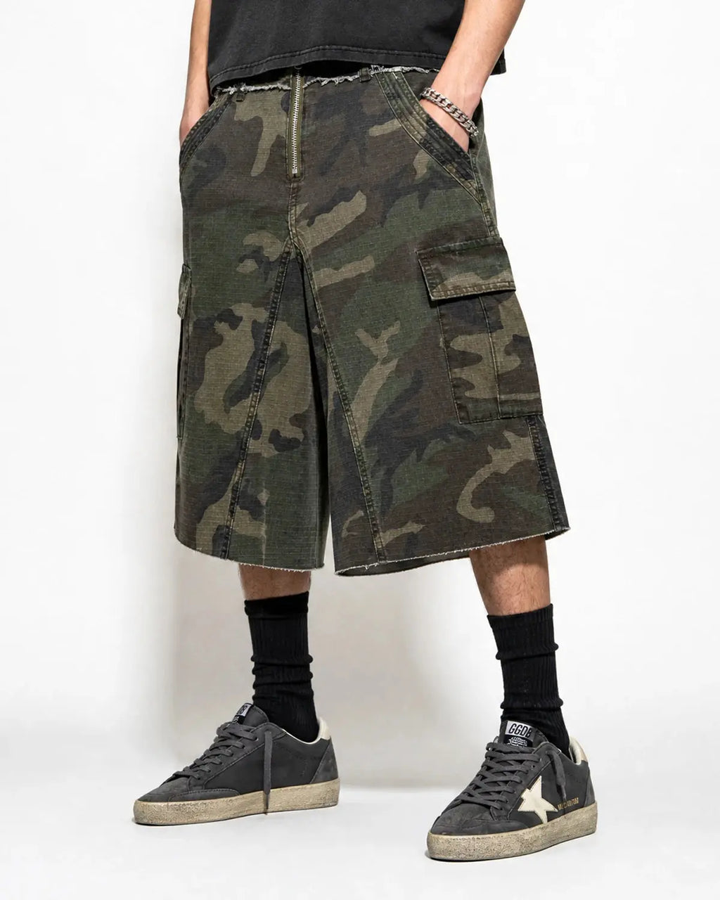 Camo utility longline shorts by INFLATION featuring a camouflage pattern, multiple pockets, and a relaxed streetwear fit.