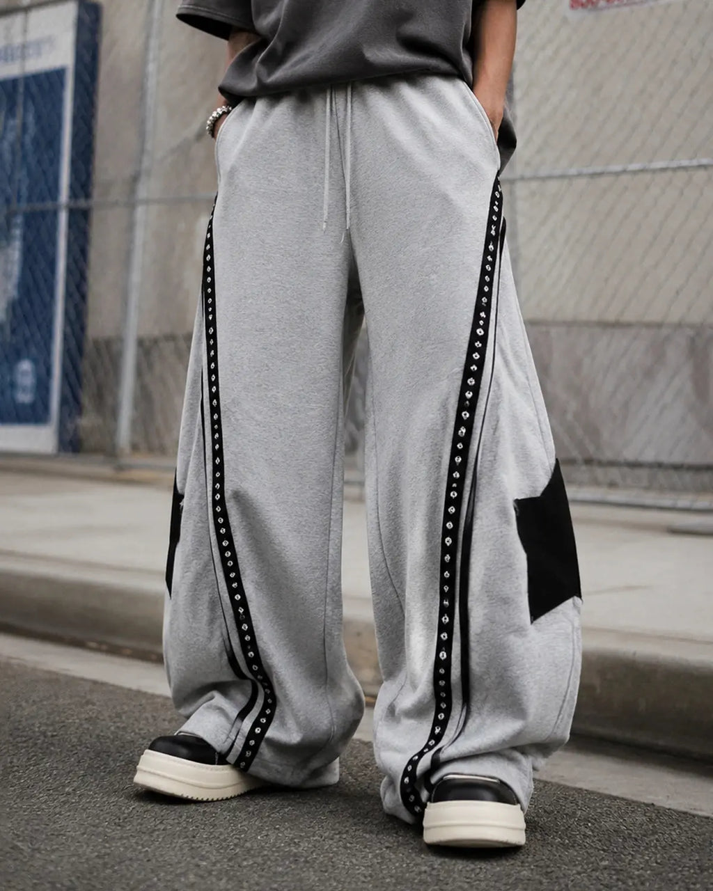 Contrast patchwork barrel sweatpants by INFLATION with bold color blocks and relaxed fit, displayed on a hanger.