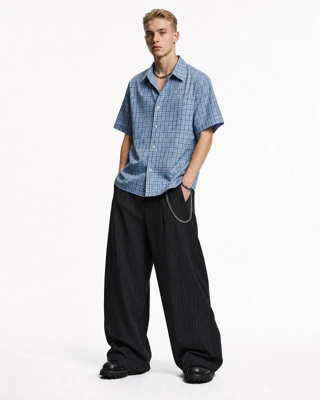 Inflation brand pinstripe pleated barrel tailored pants with a high waist and relaxed fit, featuring vertical pinstripes and tailored cuffs.
