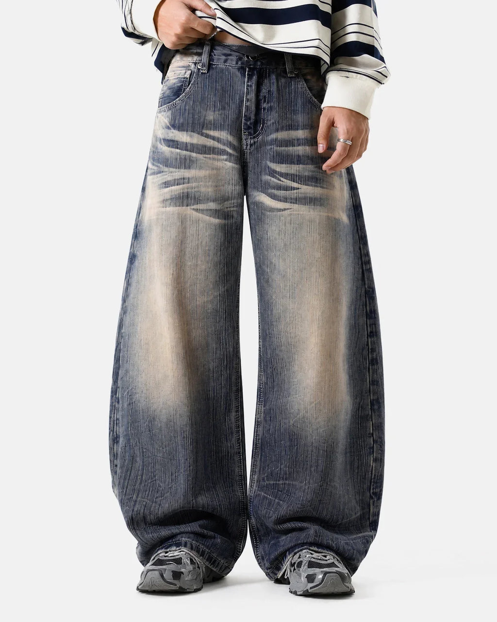 Bamboo weave distressed jeans by INFLATION with a relaxed fit and raw hem, displayed on a hanger against a neutral background.