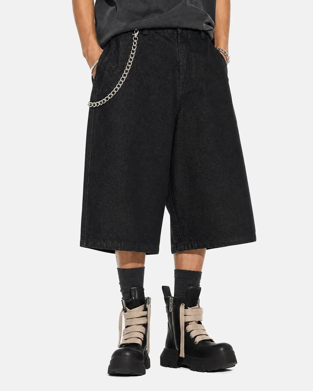 Black baggy long jorts by INFLATION, stylish streetwear denim shorts with a relaxed fit and frayed hems, casual and trendy.