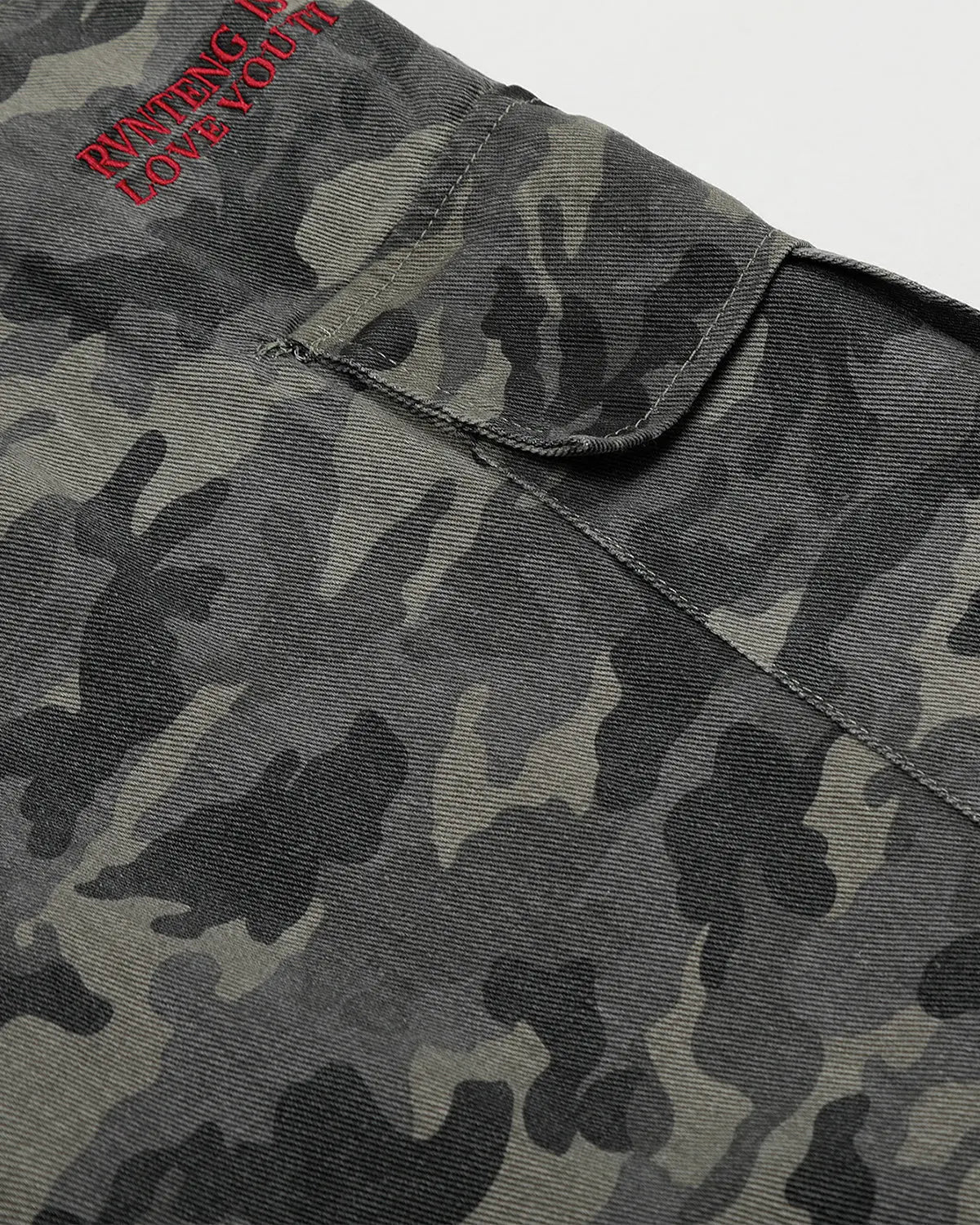 Embroidered camo cargo shorts by INFLATION, featuring green camouflage fabric and multiple utility pockets.