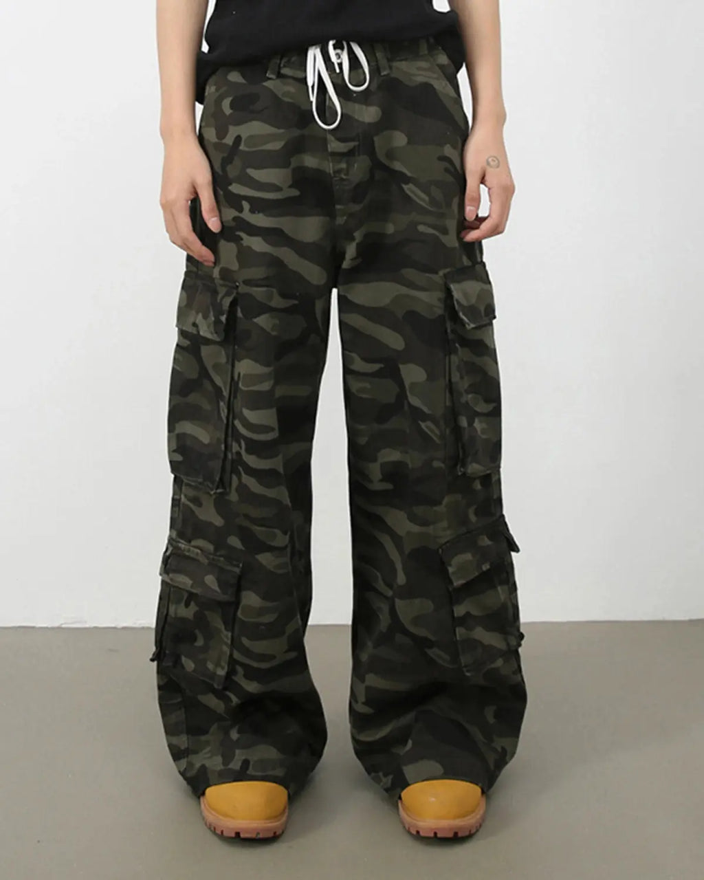 Vintage camo cargo pants from INFLATION featuring a relaxed fit and multiple pockets, styled for streetwear fashion.