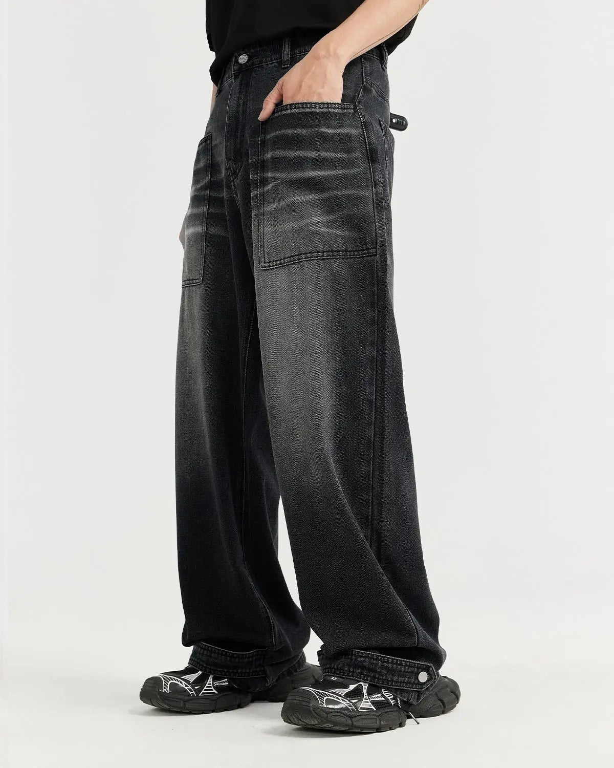 Black washed baggy jeans by Inflation Streetwear with relaxed fit and distressed details, shown on a model.