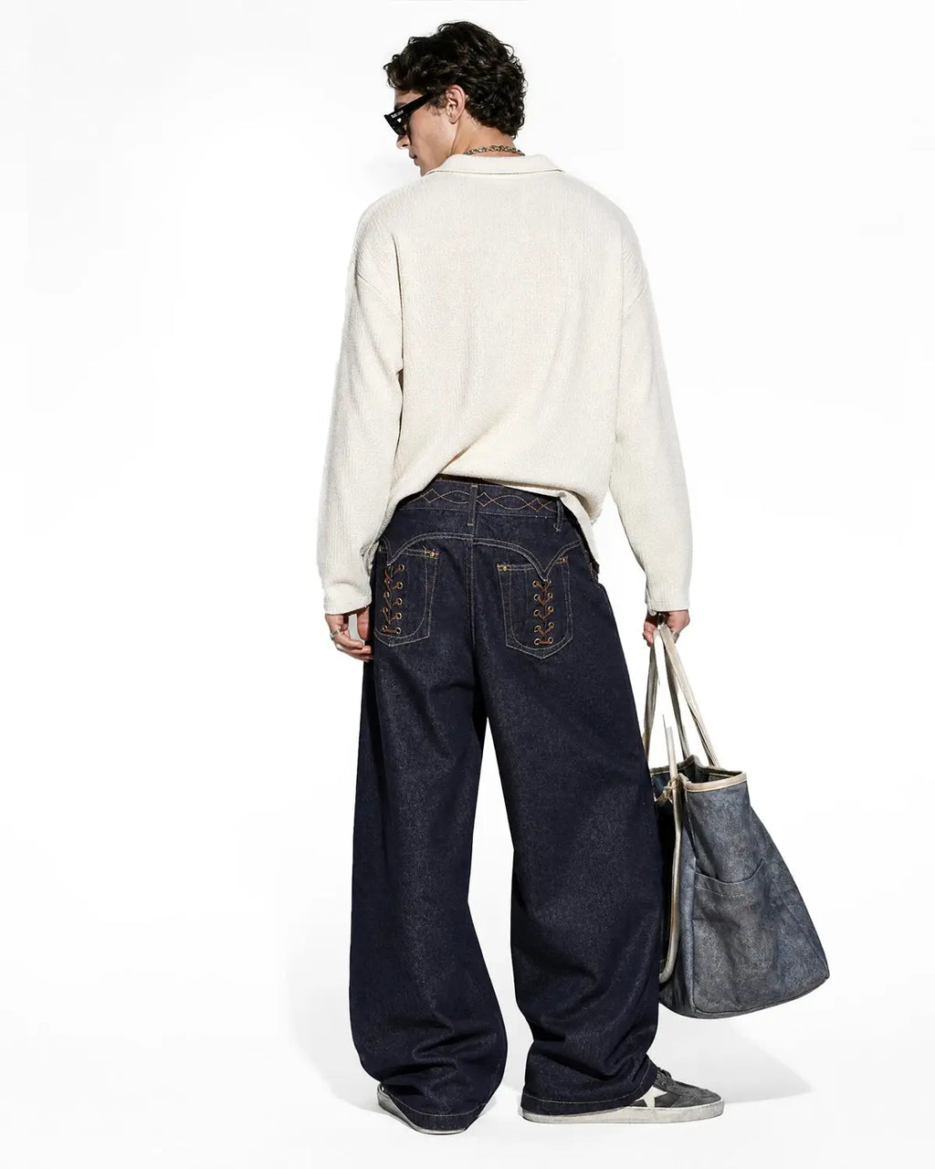 Inflation Streetwear side lace-up raw baggy jeans with distressed denim and relaxed fit, displayed on a hanger.