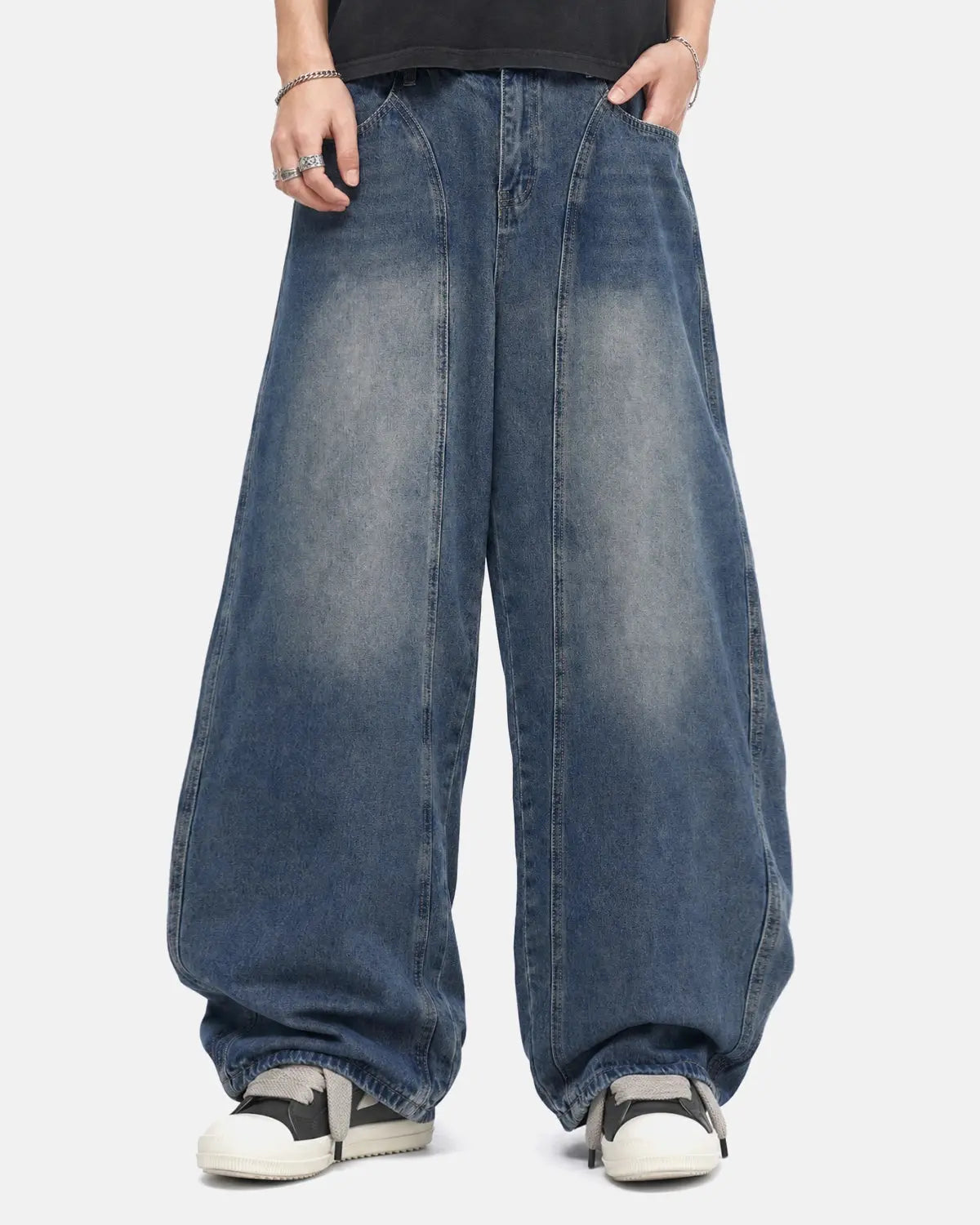 Deconstructed barrel jeans by INFLATION featuring distressed details and unique streetwear style, shown on a model.