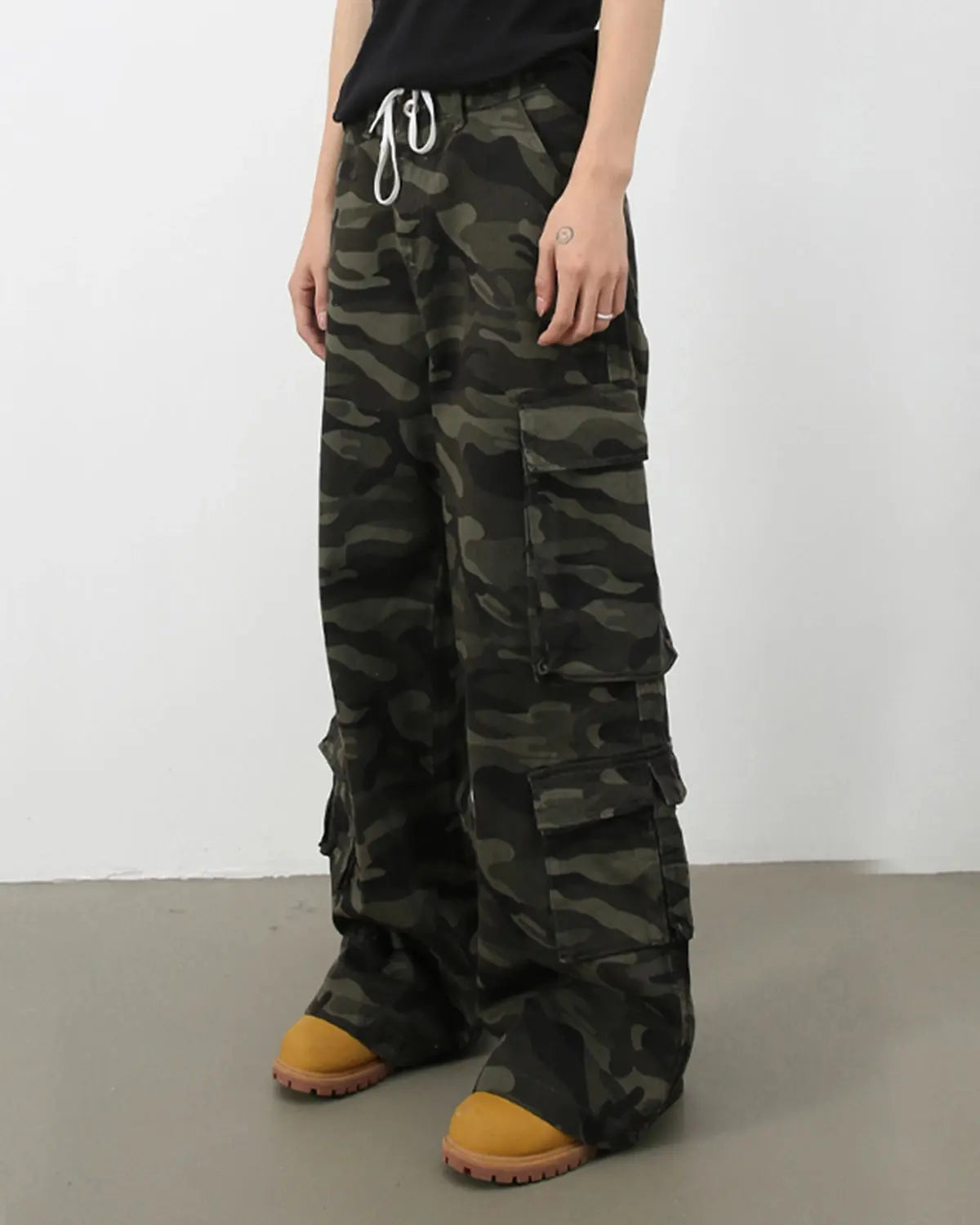 Vintage camouflage cargo pants by INFLATION, streetwear style with multiple pockets and relaxed fit, shown on a model.