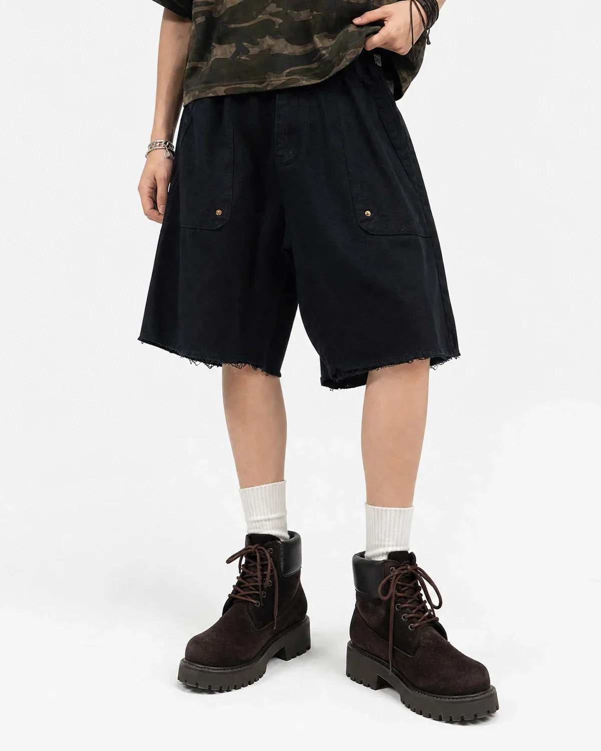 Inflation Streetwear frayed hem camo knee-length shorts with distressed edges and camouflage pattern on a model.