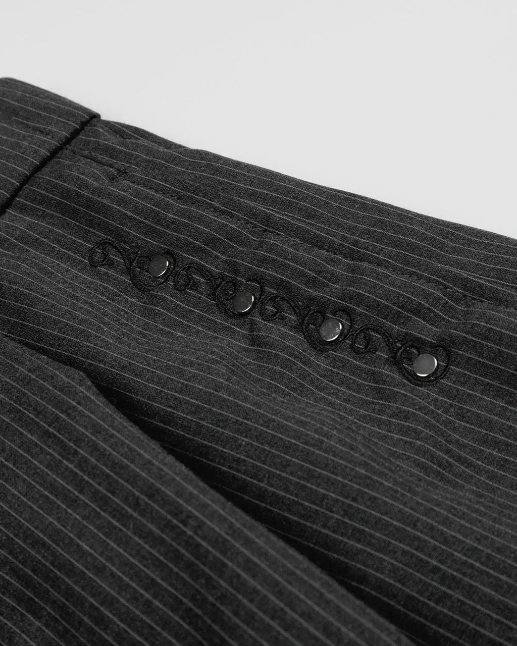 Pinstripe stud detail tailored shorts by INFLATION, stylish streetwear pants with pinstripe pattern and metal stud accents.