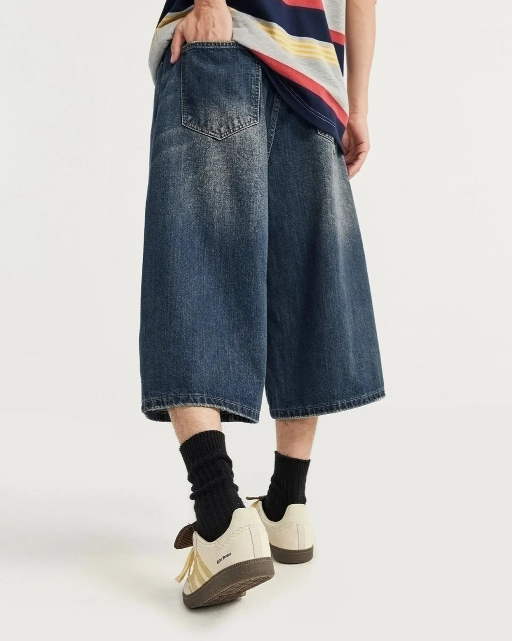 Acid washed longline baggy denim jorts by INFLATION, featuring distressed details and a relaxed fit, styled as casual streetwear pants.
