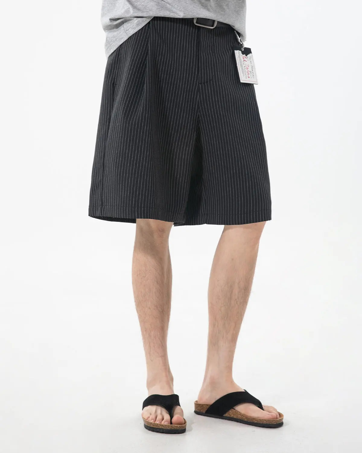 Inflation brand pinstripe pleated tailored shorts, stylish pants with a high waist and sharp pinstripe pattern.
