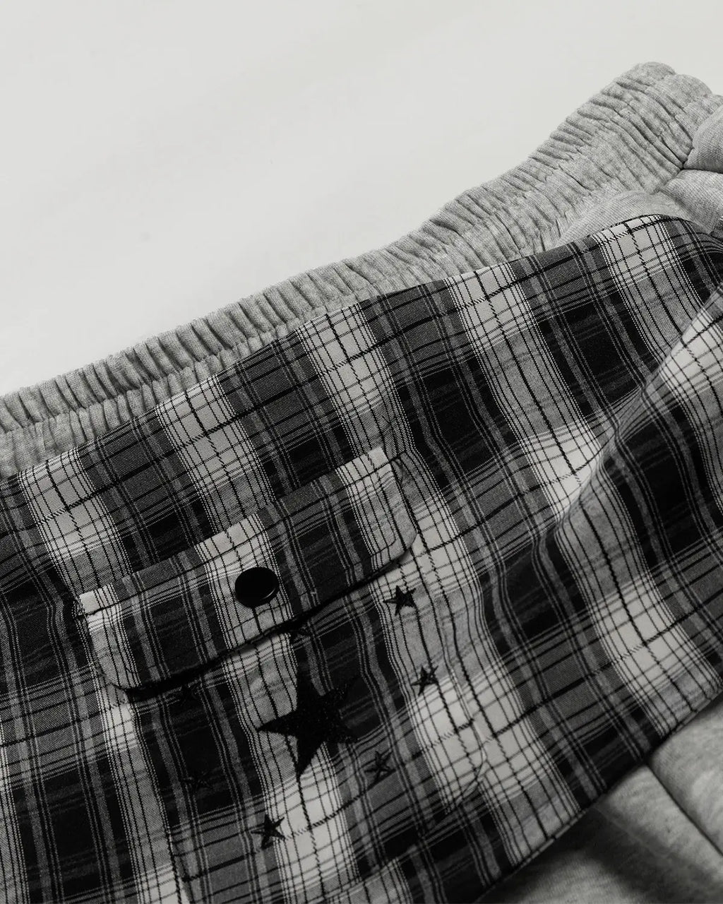 Plaid layered baggy sweatpants by INFLATION, featuring a relaxed fit and streetwear style with a layered plaid design.
